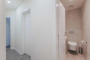 Un bagno moderno con WC, bidet e doccia.