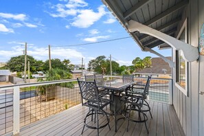 A balcony with a table and chairs, a railing, and a view of the neighborhood. - Beach House Hideaway Near Schooners, Sand & Grand Lagoon Fun (Panama City)