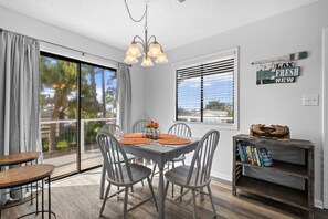 A dining area with a table, chairs, and a chandelier. - Beach House Hideaway Near Schooners, Sand & Grand Lagoon Fun (Panama City)
