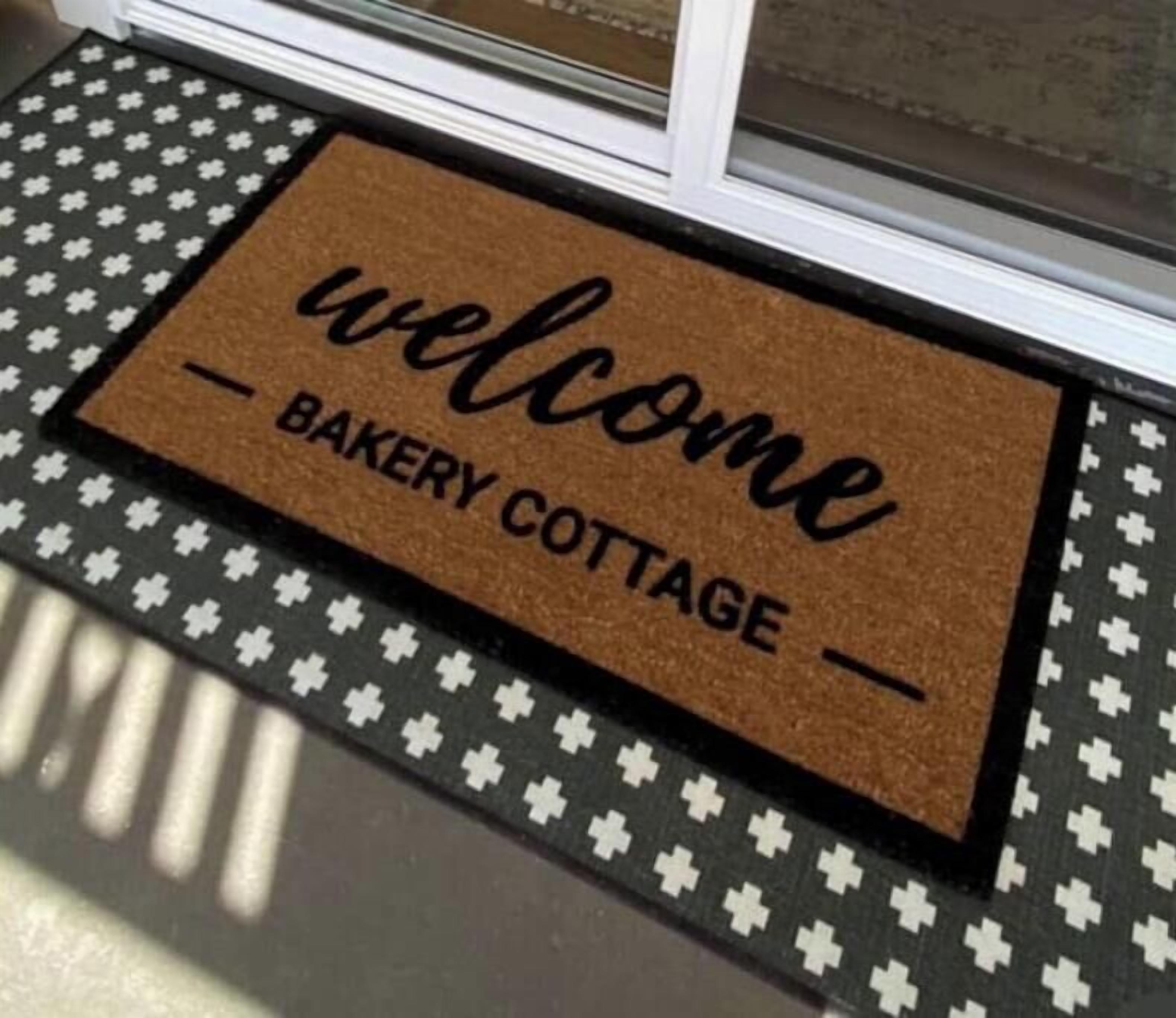 Un paillasson avec les inscriptions « bienvenue » et « charmante boulangerie ».