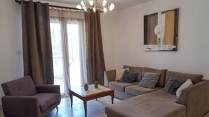 A living room with a sofa, armchair, and a coffee table. - Spacious apartamens nearthe mall (Pafos)