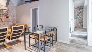 Ein modernes Interieur mit freiliegenden Holzbalken, einem Glastisch und einer Wand mit Muster.