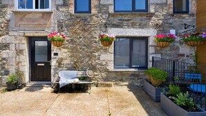 A stone building with a door, windows, and hanging flower baskets. - Wonderful  villa for 6 people with WIFI (Porthleven)