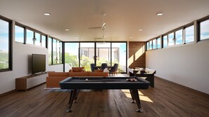 A spacious room with a pool table, a sofa, and a TV. - Chic 2BR | Beach, Town & Elevated Views (Huatulco)