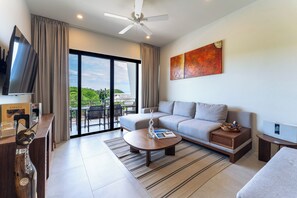 A modern living room with a sofa, coffee table, and TV. - Chic 2BR | Beach, Town & Elevated Views (Huatulco)
