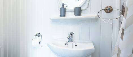 Un baño con lavamanos blanco, un espejo y un inodoro.