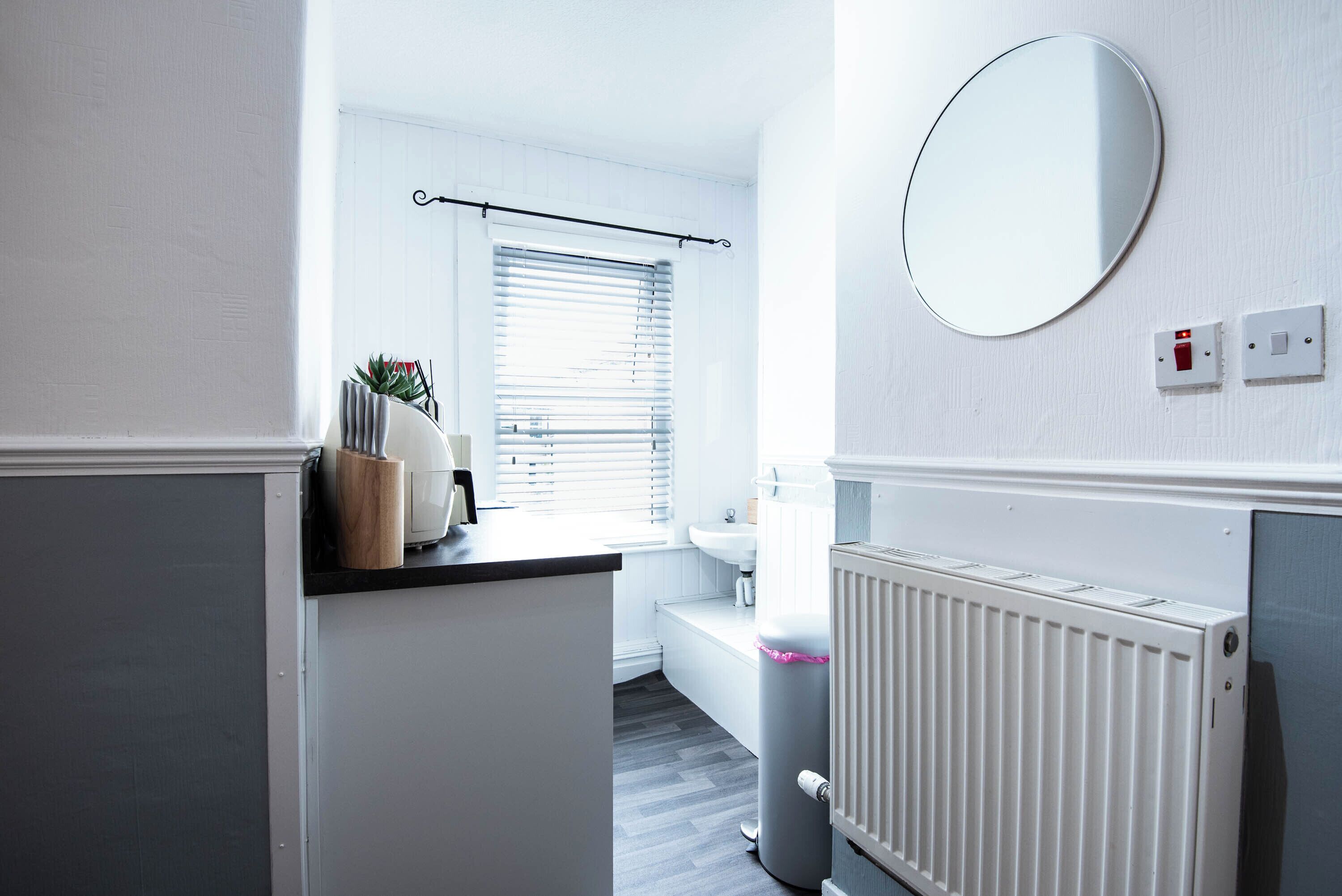 A modern bathroom with a toilet, sink, and a radiator.