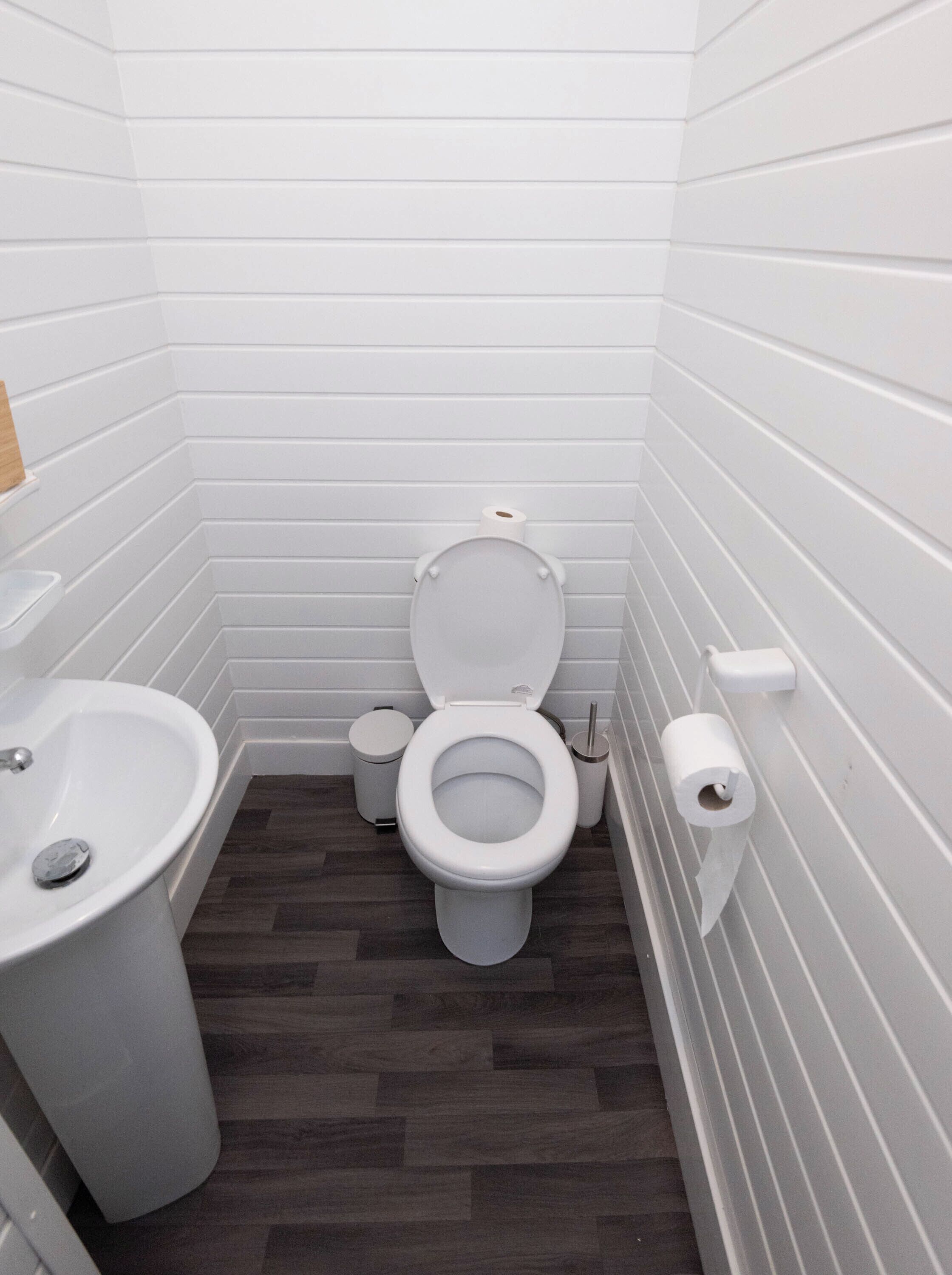 A small, modern bathroom with a toilet, bidet, and sink.