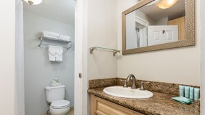 A bathroom with a toilet, sink, and mirror. - Studio w/Kitchenette, AC, WiFi, & Flat Screen - Waikīkī Grand #400 (Honolulu)