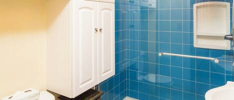 Ein Badezimmer mit Toilette, einer Dusche mit Glastür und einem Waschbecken.