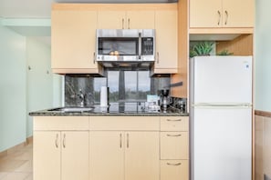A kitchen with a microwave, refrigerator, and a sink. - Ocean View Studio w/Kitchenette- Waikīkī Grand 709 (Honolulu)