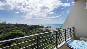 Ein Balkon mit Blick auf das Meer und Palmen.