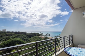 A balcony with a view of the ocean and palm trees. - Ocean View Studio with Kitchenette - Waikīkī Grand #910 (Honolulu)