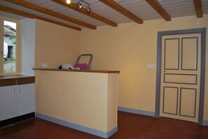 A kitchen with a wooden countertop, a sink, cabinets, and a door. - 3-star, fully equipped vacation rental in a quiet, rural setting (Saint-Julien-de-Coppel)