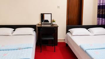 A hotel room with two beds, a desk, a chair, a mirror, and an air conditioning unit.
