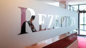 Un mostrador de recepción con un cartel que dice 'REZEPTION'.