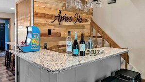 Eine Bar mit Holzwand, einem Spielgerät und Spirituosenflaschen.