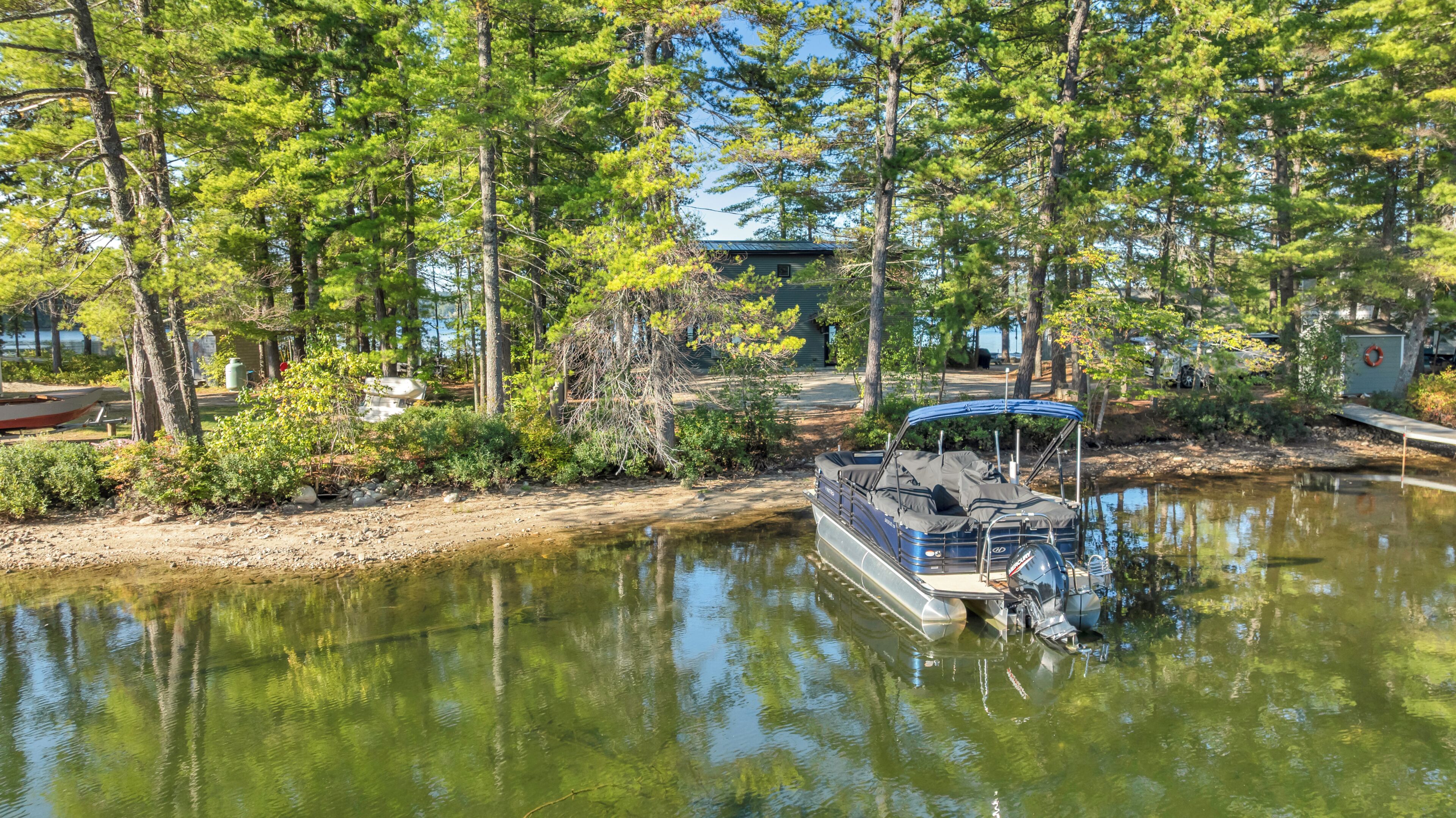Un bateau était amarré à une propriété située au bord du lac, entourée d’arbres.