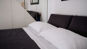 A bed with white and dark bedding, a modern room design, and a mirror on the wall. - Villa Cycas - Villa with a pool, 5 minutes from the beach in Roseto Degli Abruzzi (Abruzzo)