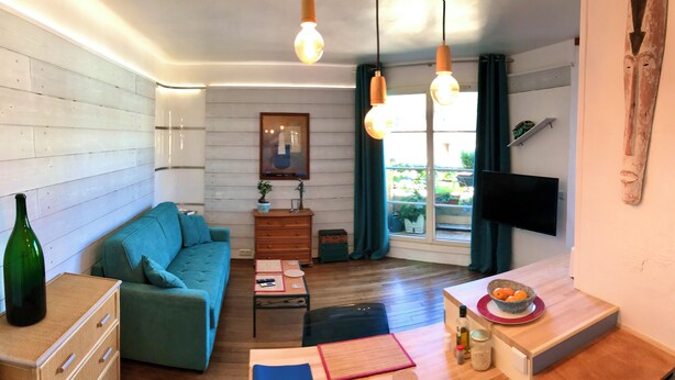 A modern living room with a sofa, a coffee table, a TV, and a wooden cabinet. - Bright studio apartment with a small terrace (Viroflay)