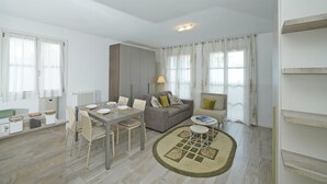 A modern living room with a dining table, sofa, and a small coffee table. - Corte Fasanella 3 in Toscolano-maderno (Toscolano Maderno)