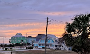 A coastal residential area with multi-story houses, a utility pole, and a palm tree. - The Beach Club | Classic AB Cottage by The Circle (Atlantic Beach)