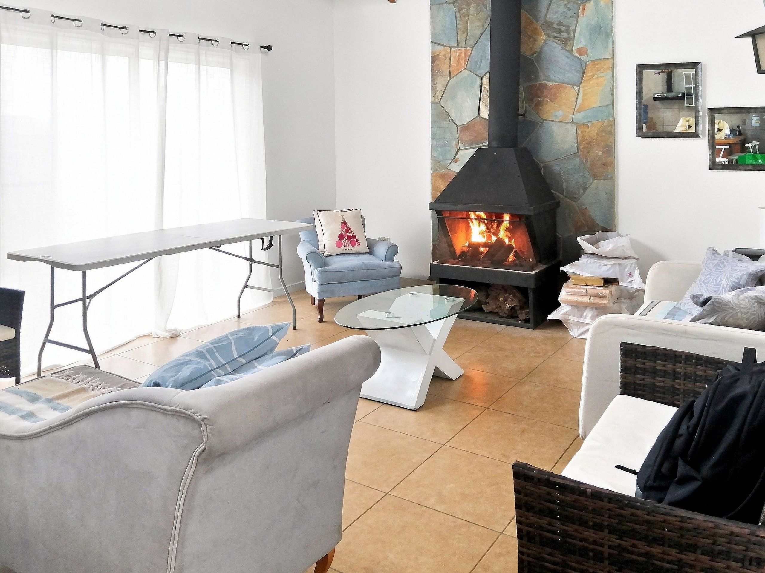 Una sala de estar con chimenea, una mesa de comedor y un sofá.