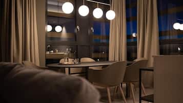 A modern dining area with a table, chairs, and pendant lights.