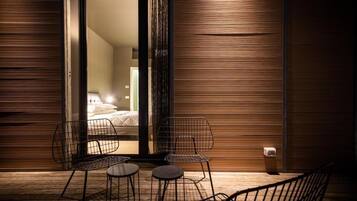 A modern room with a bed, two chairs, and a small table.