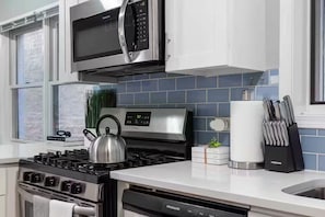Une cuisine moderne équipée d’une cuisinière en acier inoxydable, d’un four à micro-ondes et d’un lave-vaisselle.
