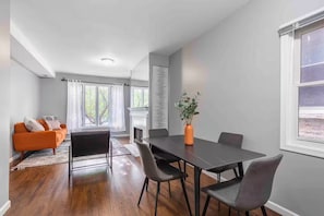 Un salon moderne avec une cheminée, un coin repas comprenant une table et des chaises, et un canapé.