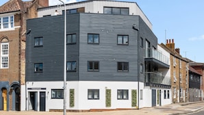 A modern building with a flat roof, multiple windows, and a balcony. - Urban Shore | By My Getaways (Brighton)