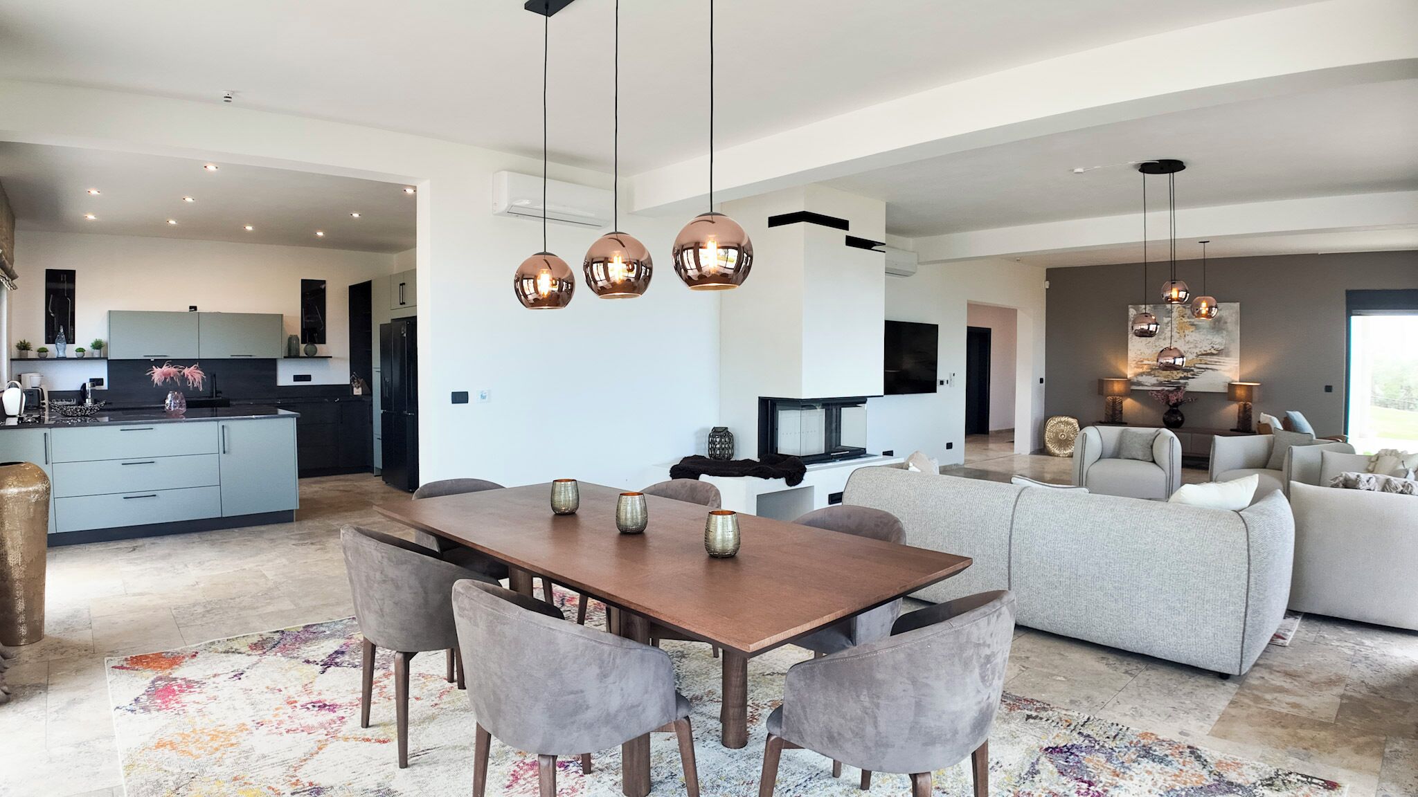 A modern living space with a dining area, kitchen, and seating area.