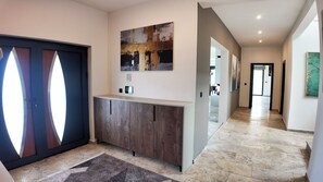 A modern hallway with a dark door, a wooden cabinet, and a tiled floor. - Exclusive luxury villa with a private pool and a view of the Adriatic Sea (Dobra Voda)