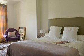 A hotel room with a bed, a chair, a nightstand, and a curtain. - Mas Saint Jean - Domaine de Malaga - New Property (Maussane-les-Alpilles)