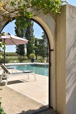 Ein Poolbereich im Freien mit Liegestühlen und einer Pergola.