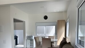 A modern living room with a sofa, coffee table, and a dining area with chairs and a table. - Diamond Riviera - Casa Nova a 30m da Praia da Ferrugem (Garopaba)