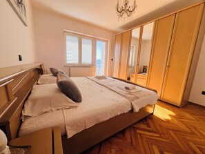 A bedroom with a wooden bed, a chest of drawers, a wardrobe, and a radiator. - A6 - Spacious apt w Pool, Terrace and sea View (Dugi Rat)