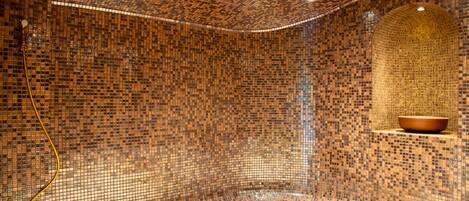 A room with mosaic tile walls and a seating area.