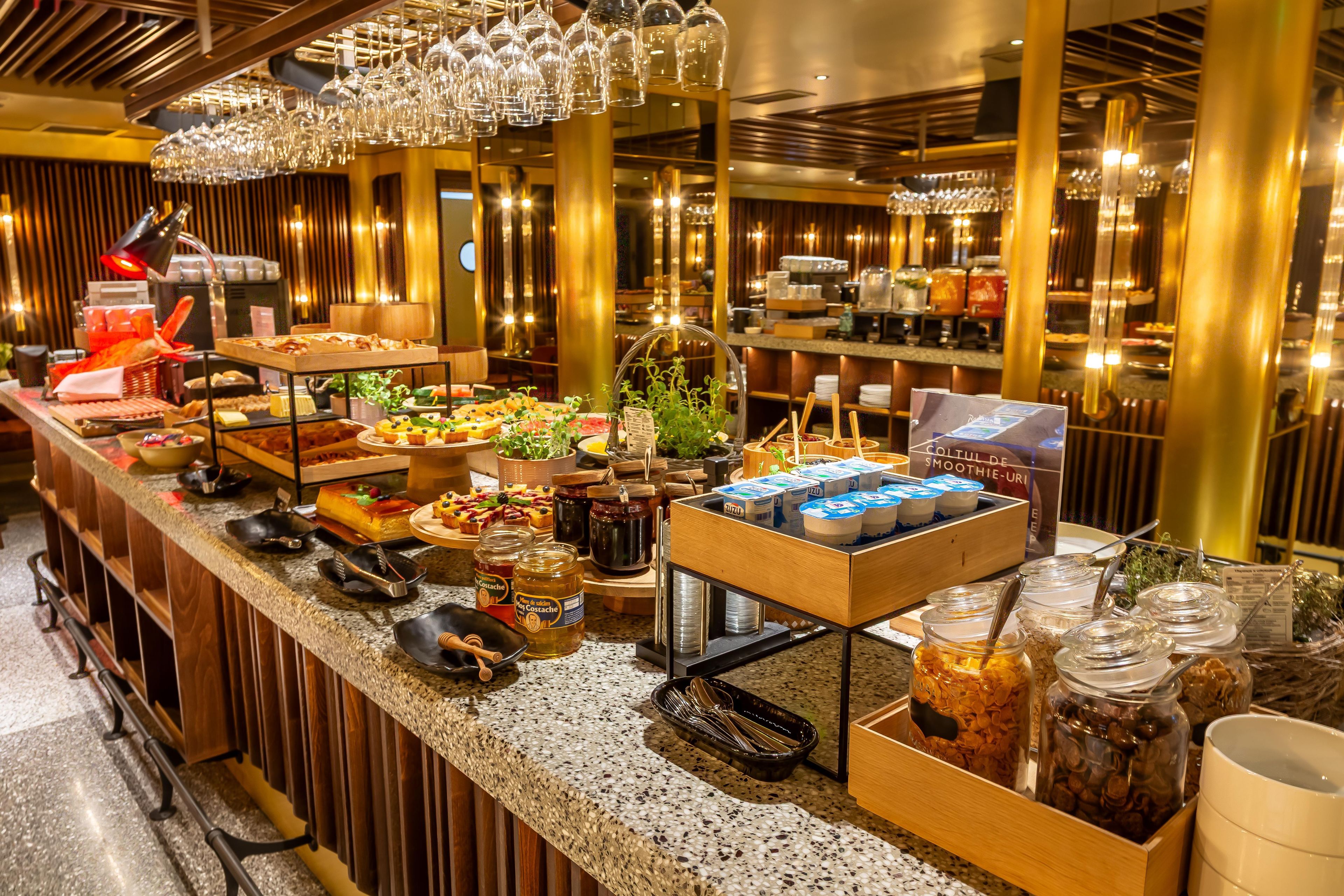 A buffet setup with various food items, utensils, and condiments.