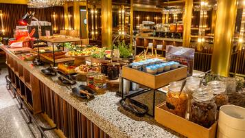 A buffet setup with various food items, utensils, and condiments.