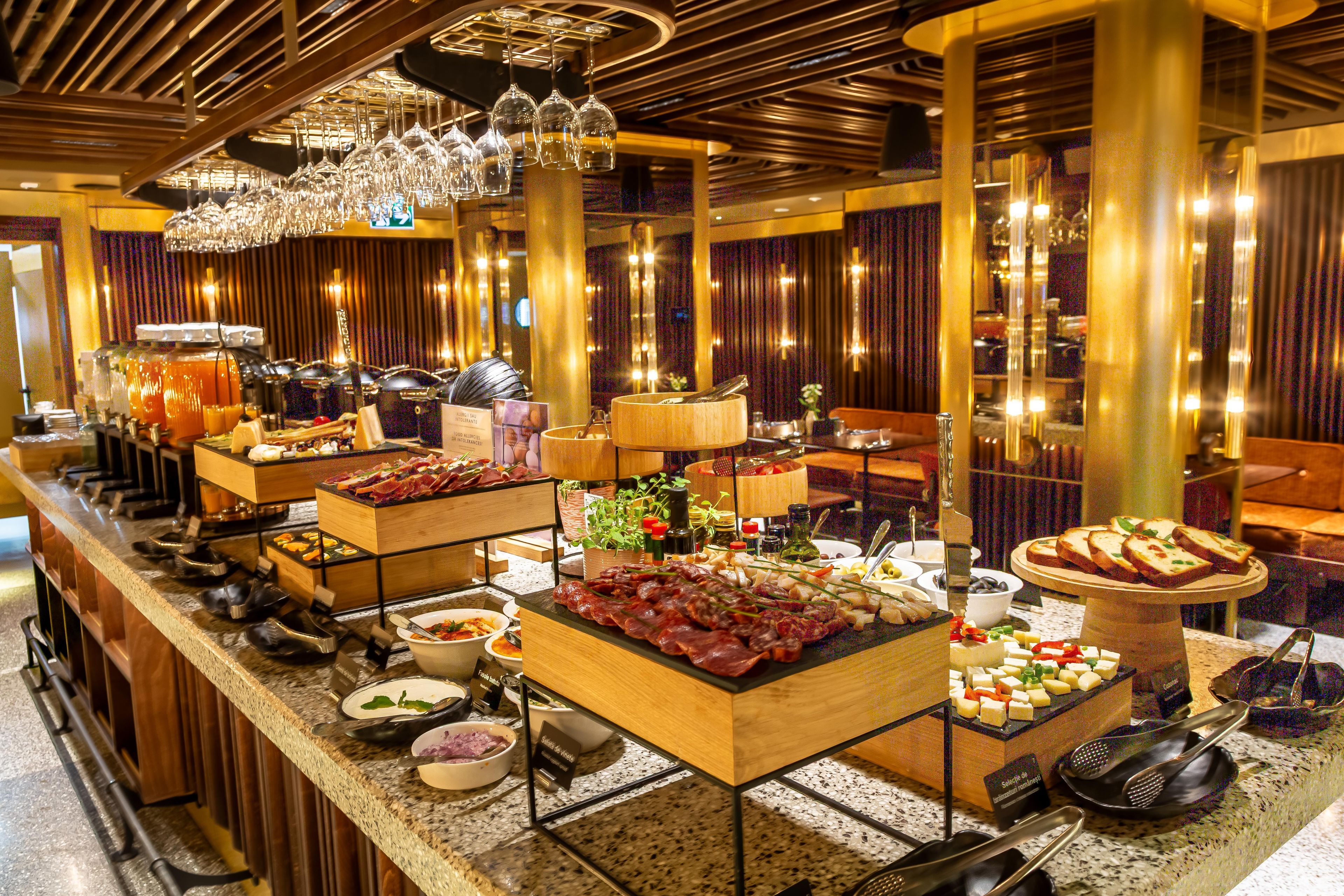 A buffet with various food items and a selection of wine glasses.