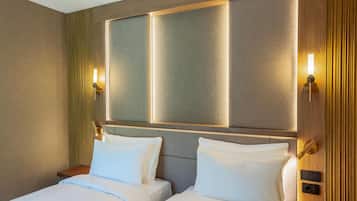 A hotel room with a large bed, two bedside tables, and wall-mounted lamps.
