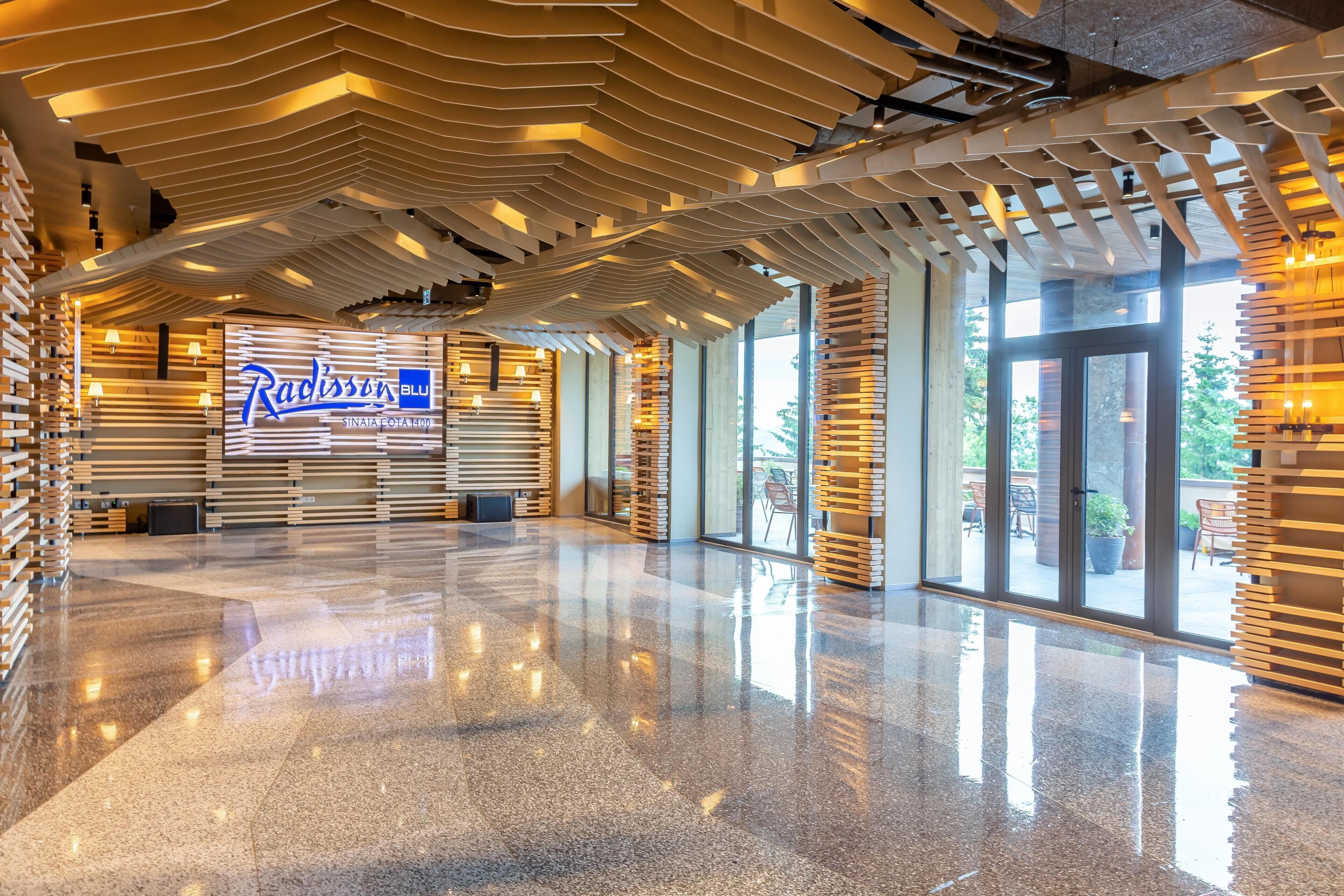 A spacious lobby with a modern design, featuring a prominent sign for Radisson Blu and a polished floor.