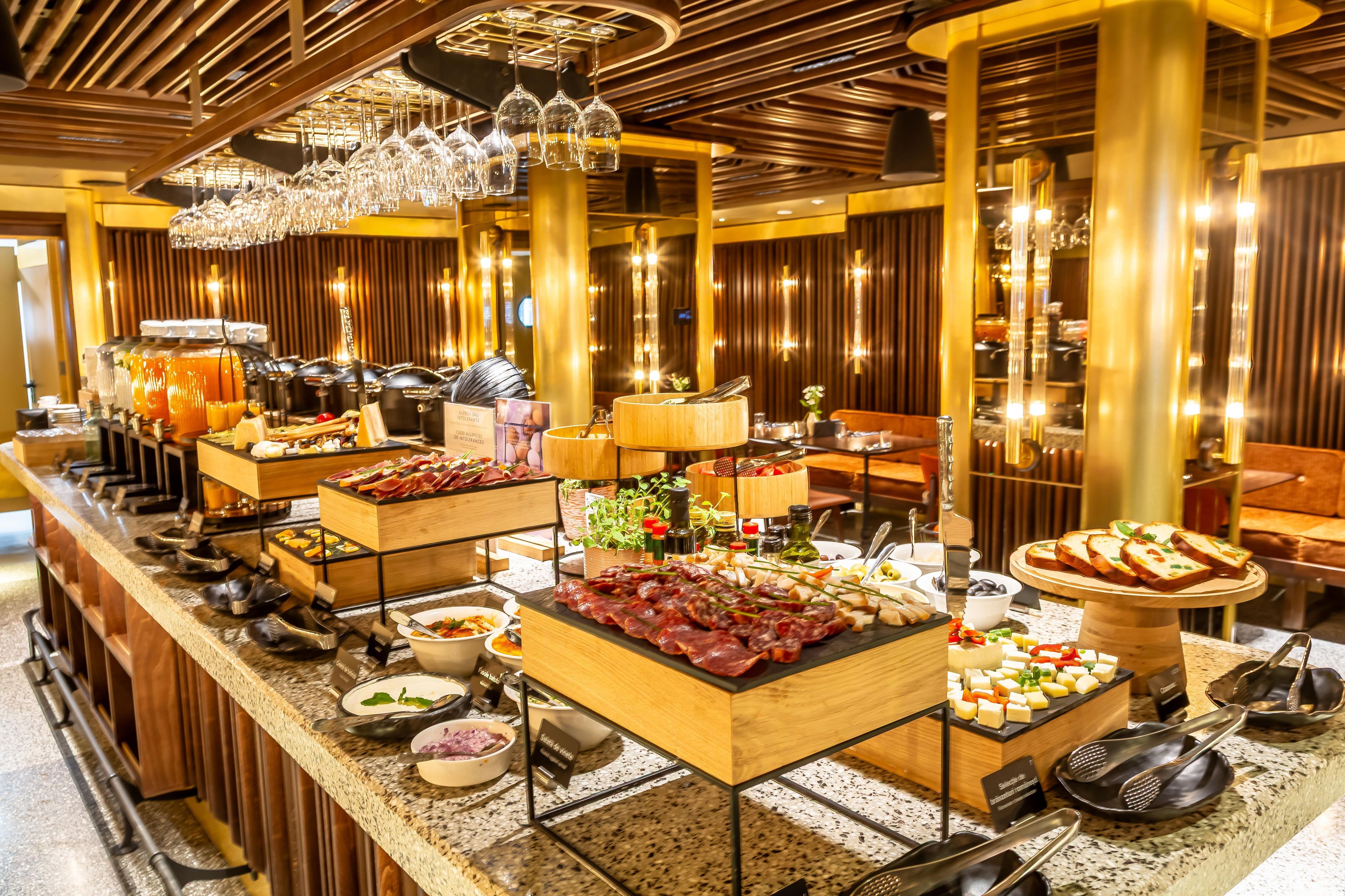 A buffet setup with various food items and utensils.