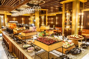 A buffet setup with various food items and utensils.