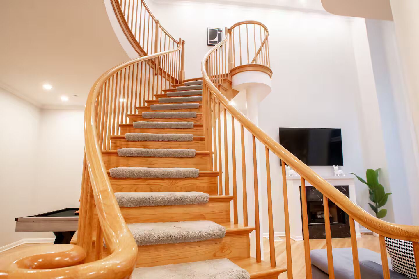 A spiral staircase with wooden railings and carpeted steps.