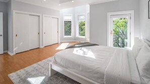 A bedroom with a bed, a window, and a door. - Gold Coast Home - Rooftop - PoolTable - Parking - Views (Chicago)