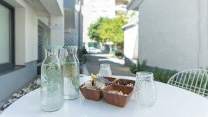 A table with glass bottles, wooden boxes, and a white chair. - Authentic Bosnian-Herzegovinian Studio & Garden in the heart of Mostar (Mostar)