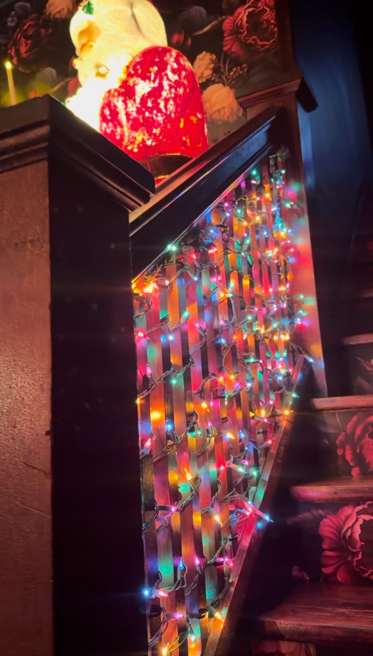 A decorative wall with colorful lights and a floral arrangement.